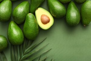 Avocados on a green background, palm leaves